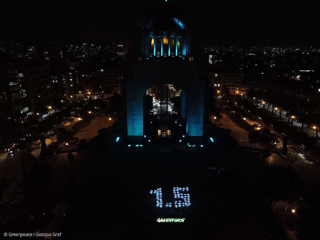 Activistas de Greenpeace México iluminan el mensaje de 1.5°C en el marco de la COP27, en el Monumento a la Revolución.