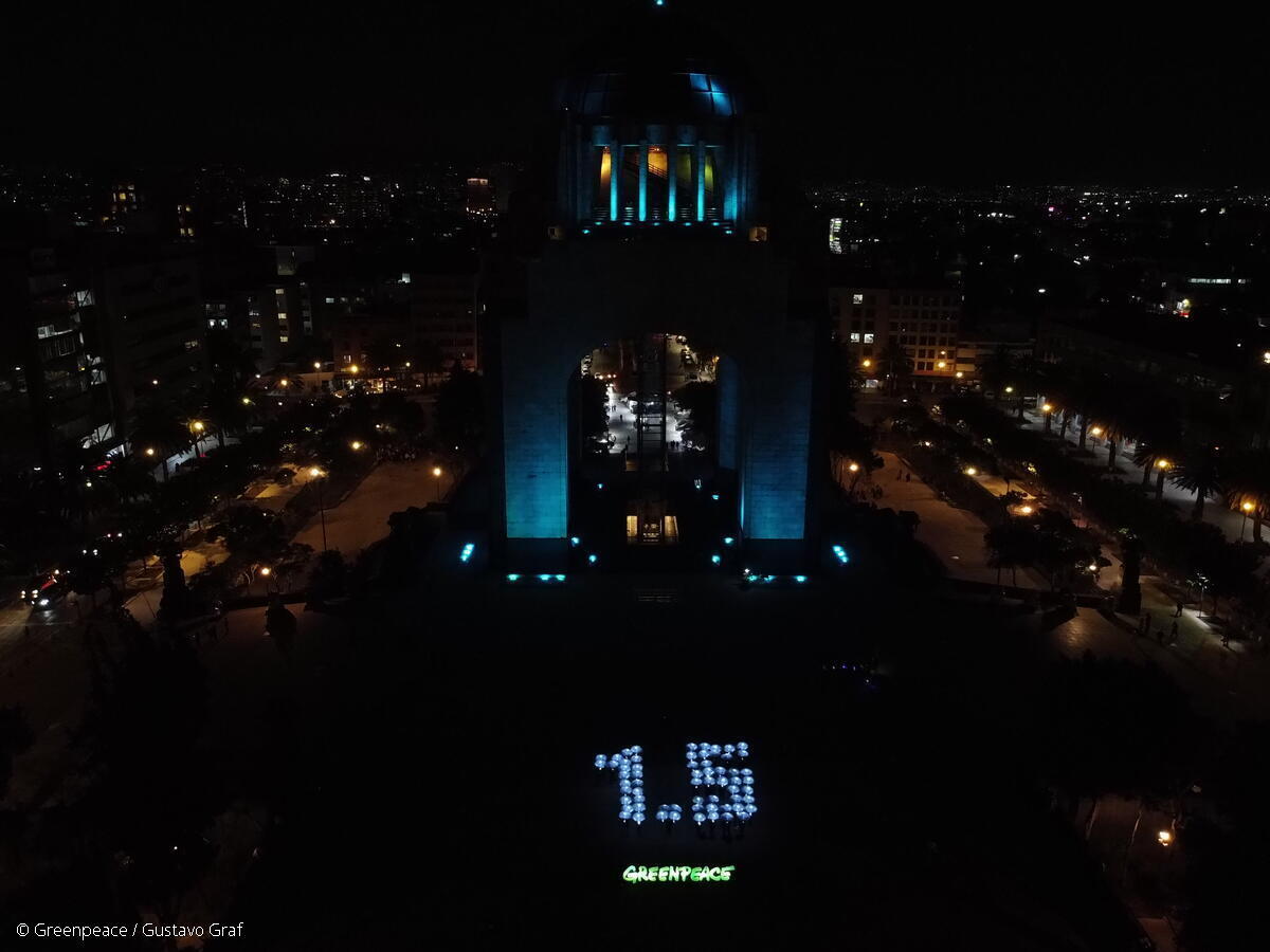 Activistas de Greenpeace México iluminan el mensaje de 1.5°C en el marco de la COP27, en el Monumento a la Revolución.
