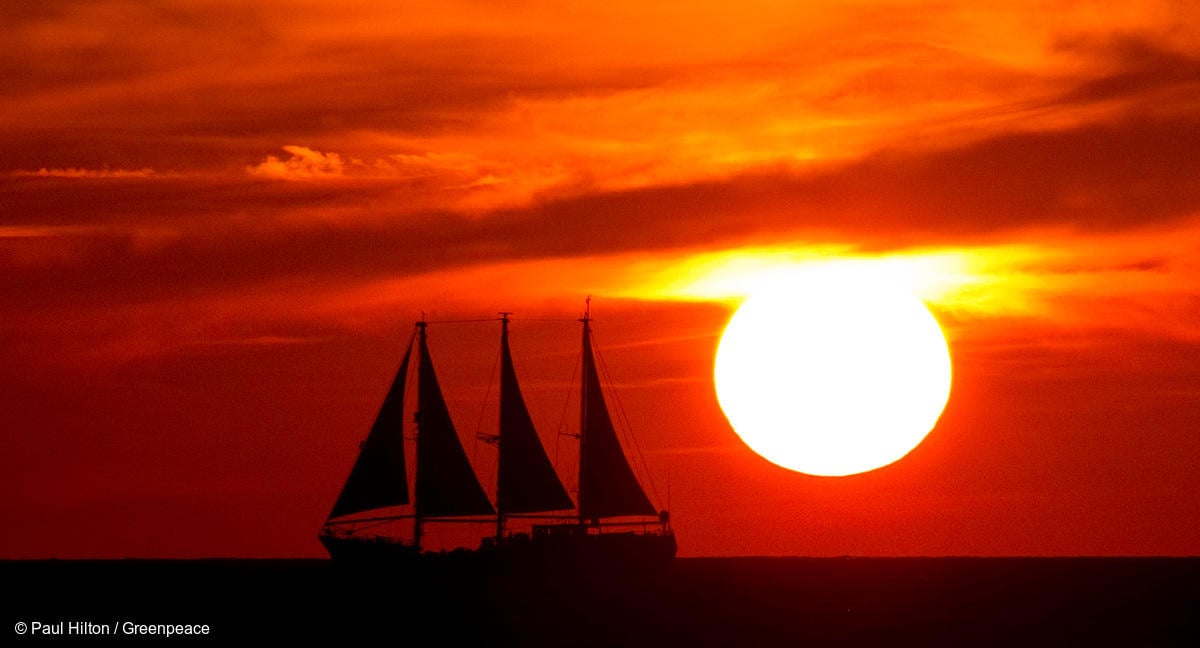 Fotografía del Rainbow Warrior, mientras navega en el Mediterráneo al atardecer.