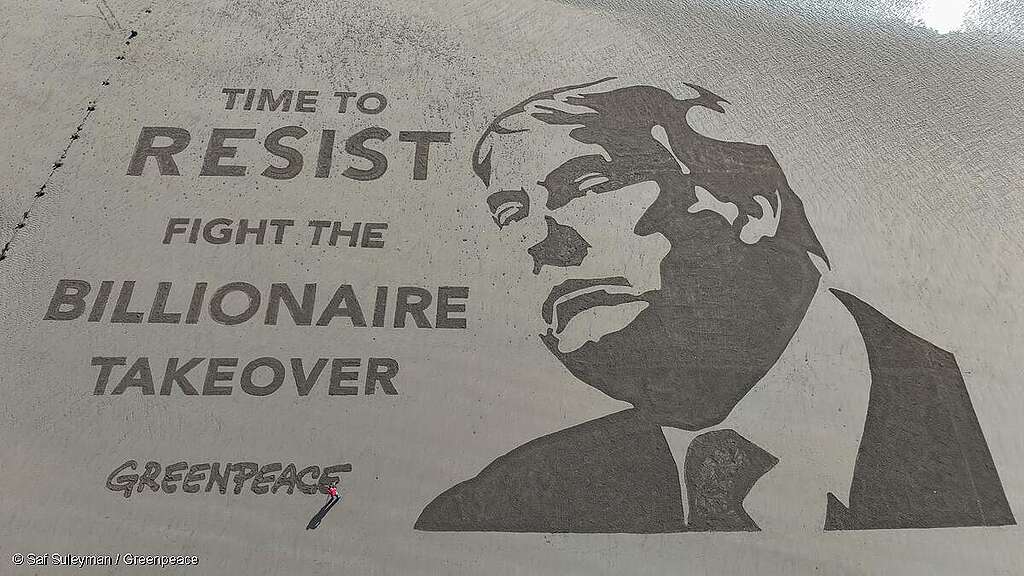 Retrato gigante del presidente Donald Trump grabado en la arena con el mensaje: "Es hora de resistir: lucha contra la toma de control multimillonaria".