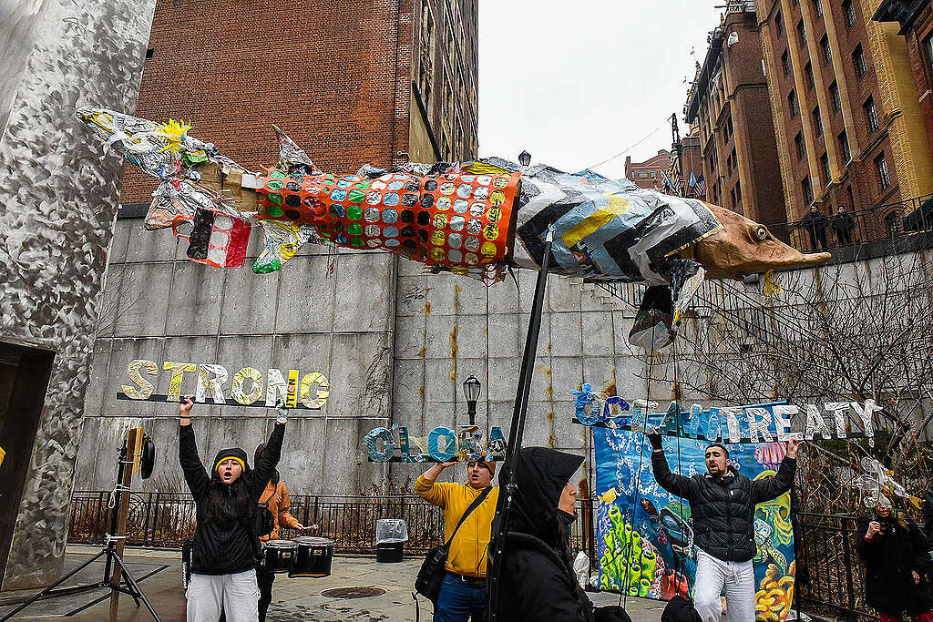 Activistas de Greenpeace con instalación artística hecha de plásticos con la que se lee "Un fuerte tratado global de océanos ya".