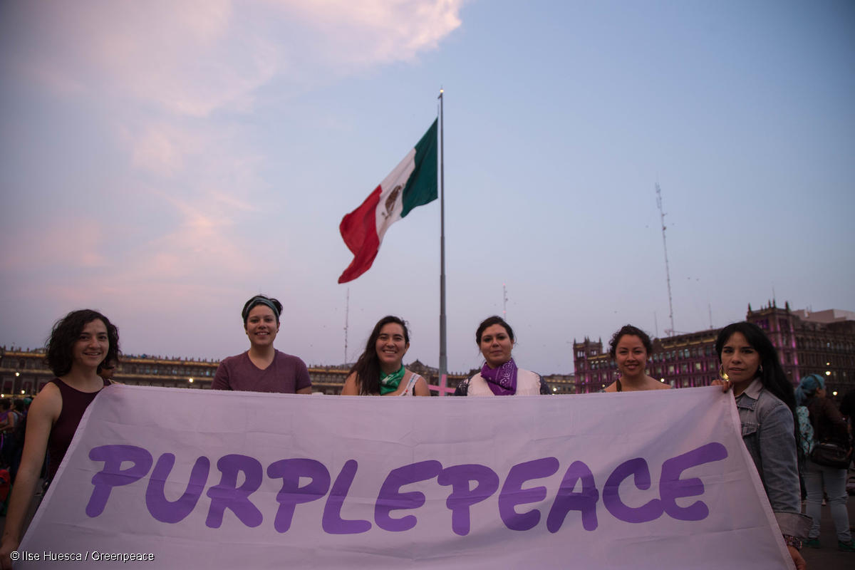 Mujeres del staff de Greenpeace México en la Marcha del Día Internacional de la Mujer, sostiene una manta con el nombre "Purplepeace".