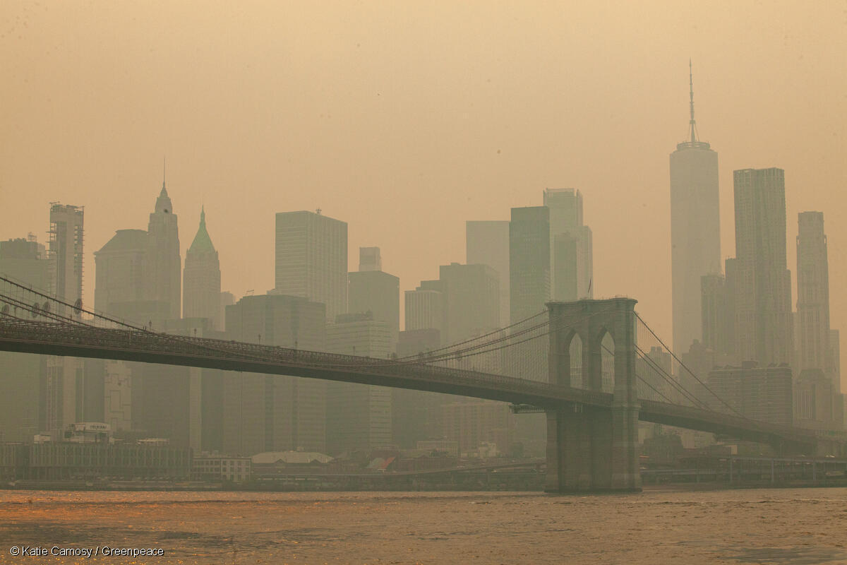 Fotografía del puente de Brooklyn y el horizonte de la ciudad de Nueva York oscurecidos por humo, evidenciando la contaminación del aire.