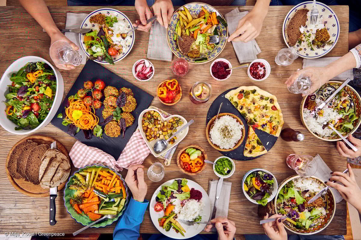Una familia comiendo una variedad de alimentos de origen vegetal en casa.