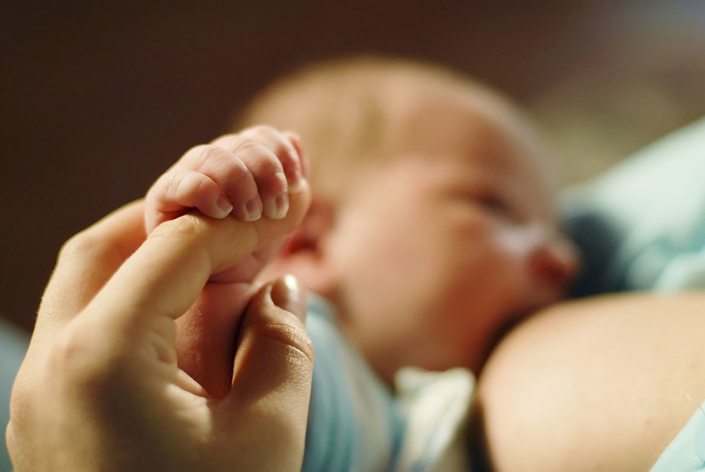 Fotografía de un bebé siendo alimentado por su madre; lactancia materna.