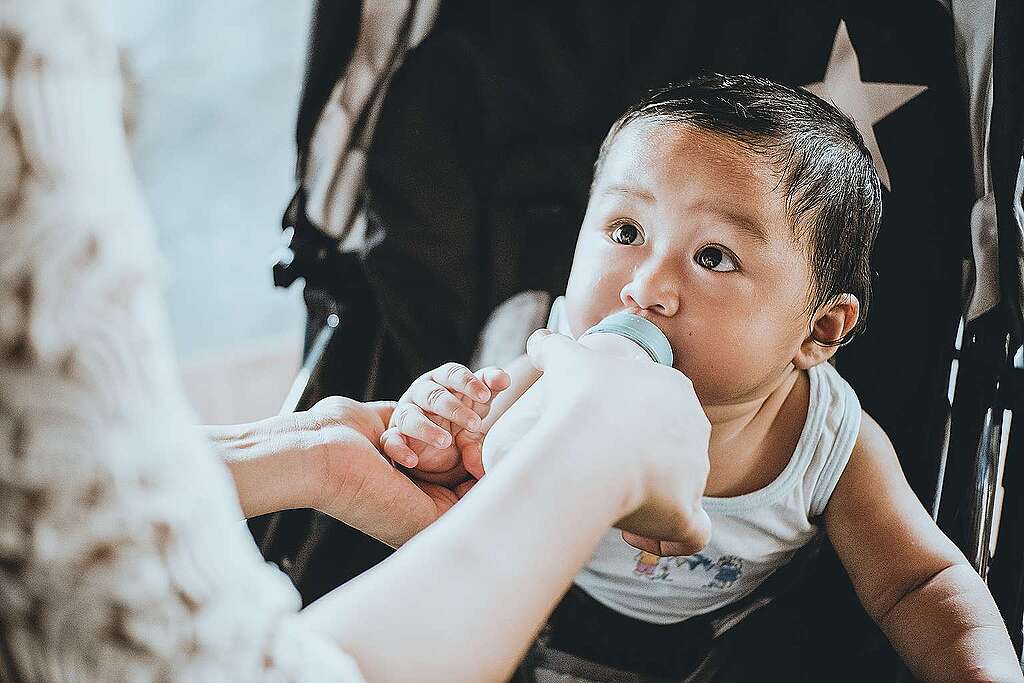 Fotografía de un bebé siendo alimentando por su madre con un biberón.