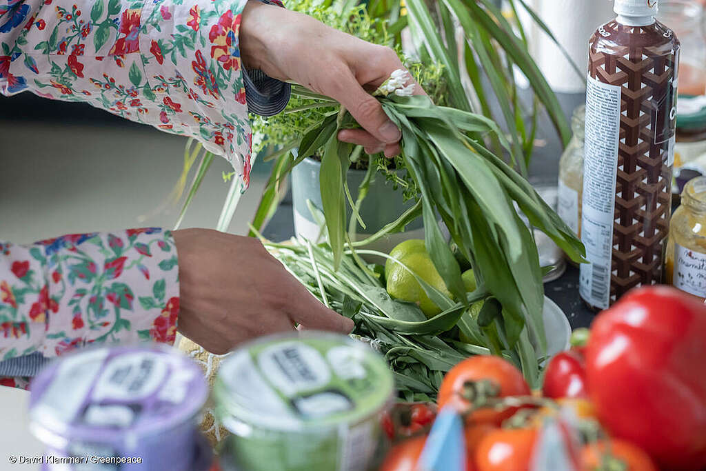 Se observan manos recogiendo frutas y verduras en un mercado local.