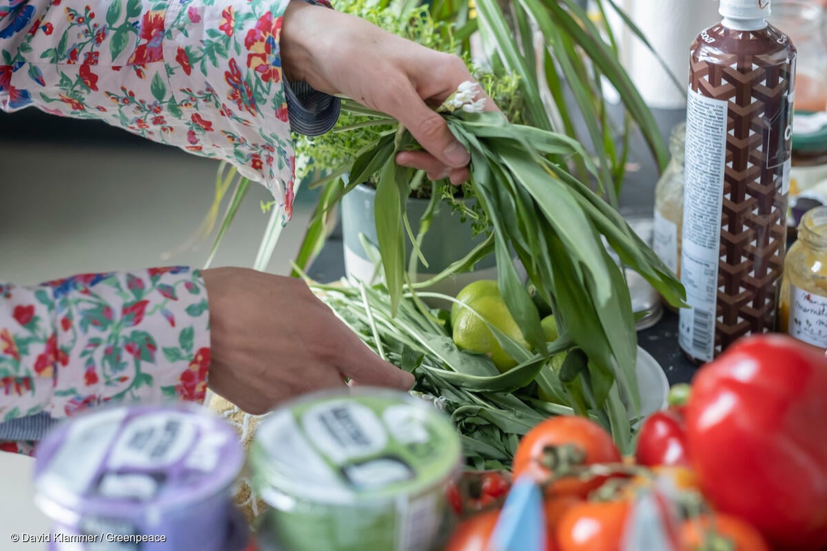 Se observan manos recogiendo frutas y verduras en un mercado local.
