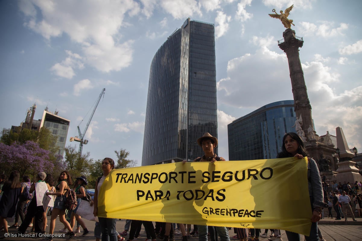 Fotografía de activistas de Greenpeace en Marcha del Día Internacional de la Mujer en México sosteniendo una manta que dice "Transporte seguro para todas".