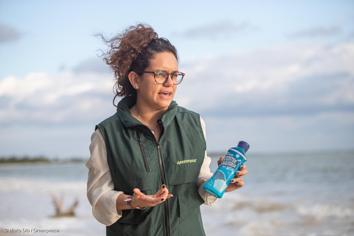 Activista de Greenpeace sostiene una botella de plástico encontrada en el Área Natural Protegida de Sian Ka'an, en la Riviera Maya en México.