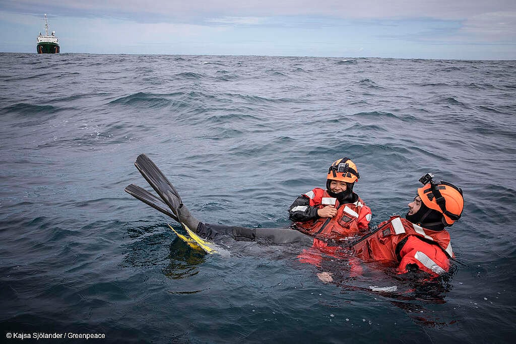 Se observa a dos activistas de Greenpeace durante un entrenamiento en barco con nadadores.