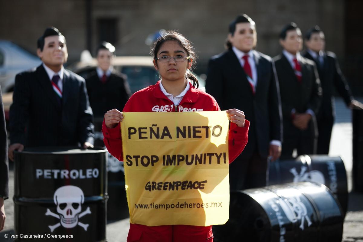 Activistas de Greenpeace México portan máscaras que imitan al presidente de México, Enrique Peña Nieto, y escenifican escenas de desastre ambiental; sostienen una pancarta que dice: "Peña Nieto destruye a México. Alto a la impunidad".