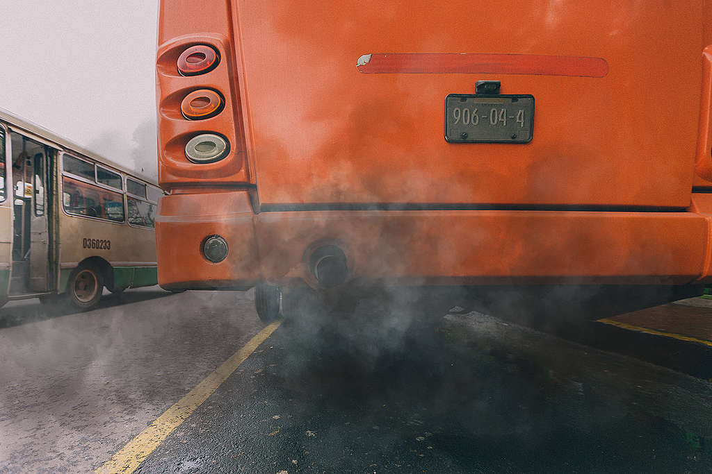 Fotografía de la parte trasera de un camión del transporte público, se observa humo negro saliendo de él.