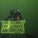 Diver with a banner, 25 meters deep. 
From the depth of the Amazon Reef, off the coast of French Guiana, deep divers aboard the Esperanza are sending a clear message for the release of the IPCC report on the Oceans, urging our leaders to act: Our Oceans, Our Climate, Our Survival. Diver: Olivier Bianchimani.