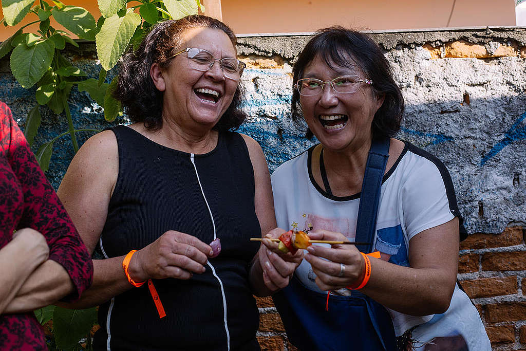 Twee vrouwen genieten van een vegetarische barbecue en elkaars gezelschap © Tuane Fernandes / Greenpeace