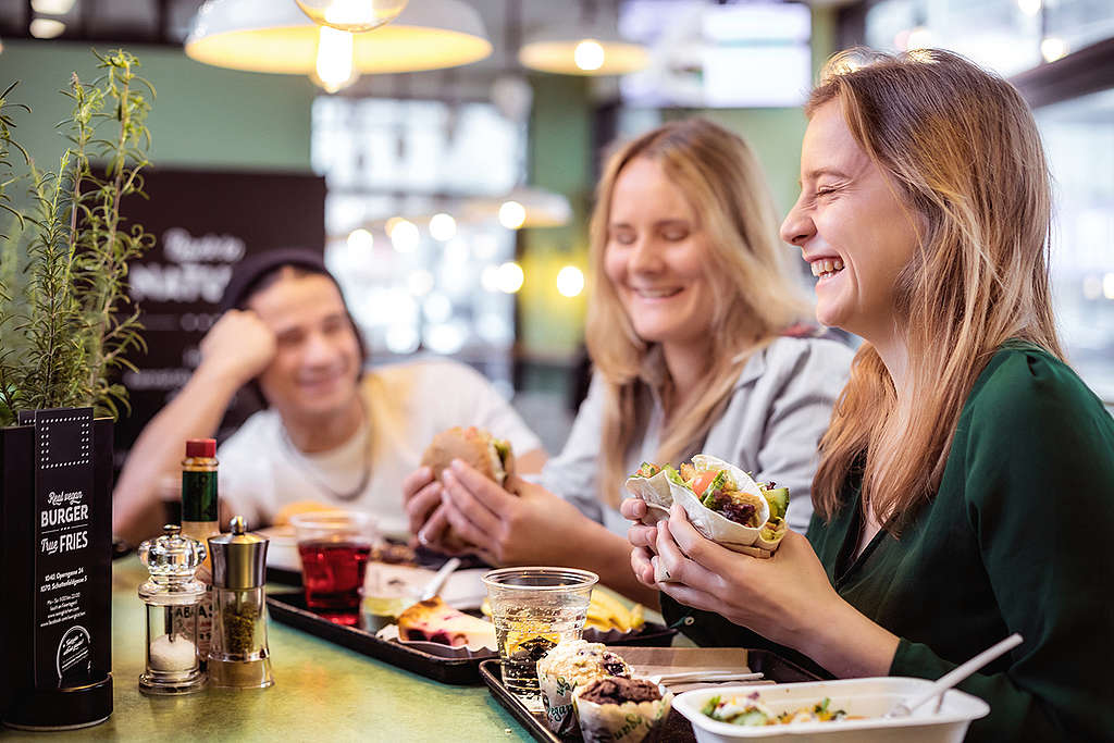 Jongvolwassenen genieten van een veganistisch burger menu © Mitja Kobal / Greenpeace