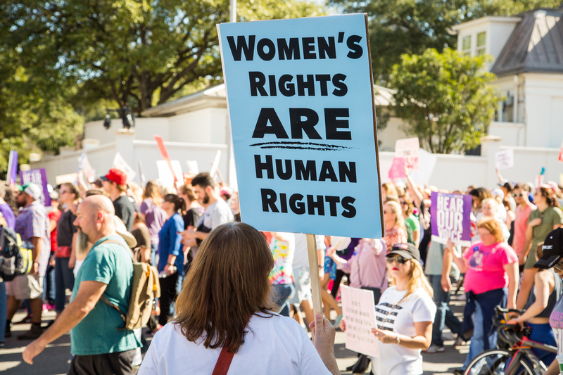 Klimaat en racisme. Een vrouw houdt tijdens de Women's March een bord omhoog met de tekst: 'Women's rights are human rights'
