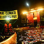 Naderev “Yeb”  Saño, Executive Director at Greenpeace Southeast Asia, is seen at dawn holding a banner along with
Filipino climate-impacted activists on kayaks and the Greenpeace Rainbow Warrior vessel blocked access to the Shell import terminal. They are calling on the Philippine’s President Marcos Jr. and world governments to make Shell and other fossil fuel companies pay for losses and damages experienced by impacted communities.
