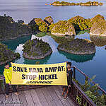Greenpeace Indonesia activists, posed for a photo with a banner reading 'Save Raja Ampat, Stop Nickel' and 'Selamatkan Hutan Papua', with the iconic karst island formation of Piaynemo, Raja Ampat in the background.