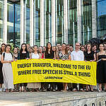 People gather outside the New Amsterdam Courthouse holding a banner reading "Energy Transfer, Welcome To The EU Where Free Speech Is Still A Thing" to mark the beginning of Greenpeace International's anti-SLAPP lawsuit against fossil fuel pipeline company Energy Transfer filed in Amsterdam, The Netherlands.