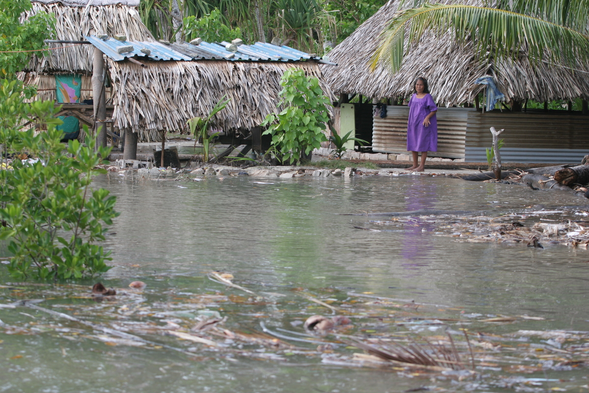 Kiribati King Tides Flooding Documentation A local woman stands and watches as a surge of seawater caused by the 'King Tides' floods into her village, Buota village, Tarawa Island, Kiribati. Greenpeace and scientists are concerned that low lying islands face permanent inundation from rising seas due to climate change.