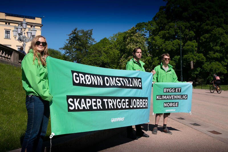 Greenpeace-aktivister demonstrerer utenfor Slottet i Oslo. Greenpeace krever mer støtte til den grønne energiomstillingen i stedet for til oljeindustrien.