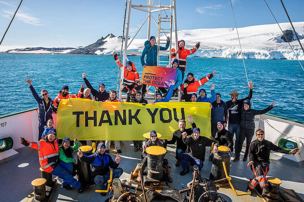 Mannskapet på Greenpeace-skipet Esperanza under skipsturen i Antarktis, med et banner som sier "thank you", "takk".