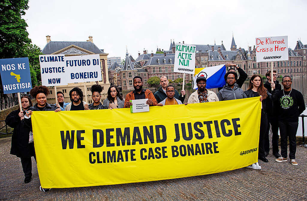 Bonaire Climate Legal Case Launch in The Hague. © Marten van Dijl / Greenpeace Aktivister med banner i Haag under lanseringen av Bonaires klimasøksmål mot Nederlands regjering.