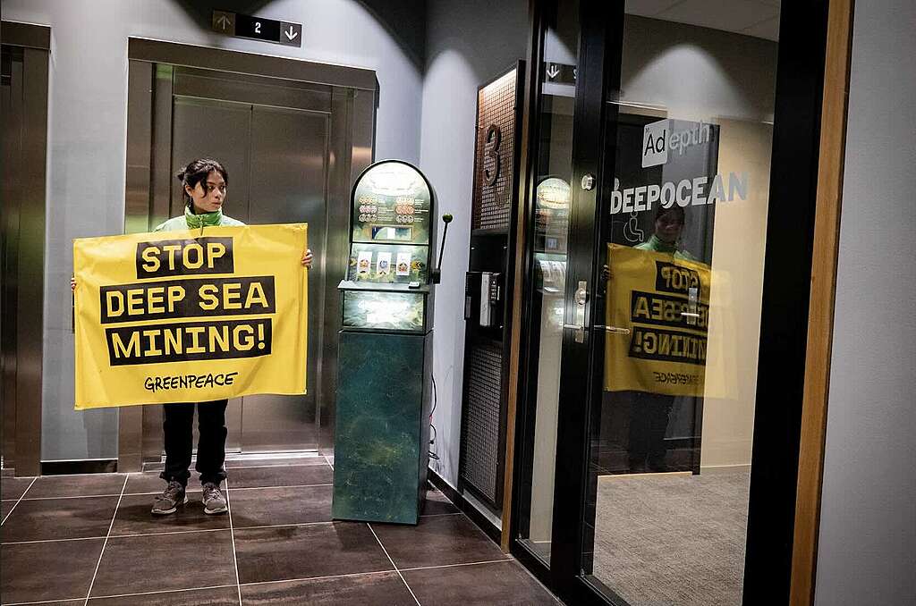 Greenpeace-aktivist utenfor kontoret til gruveselskapet Adepth Minerals, med en spilleautomat, Deep Sea Betting, som viser risikoene ved gruvedrift på havbunnen.