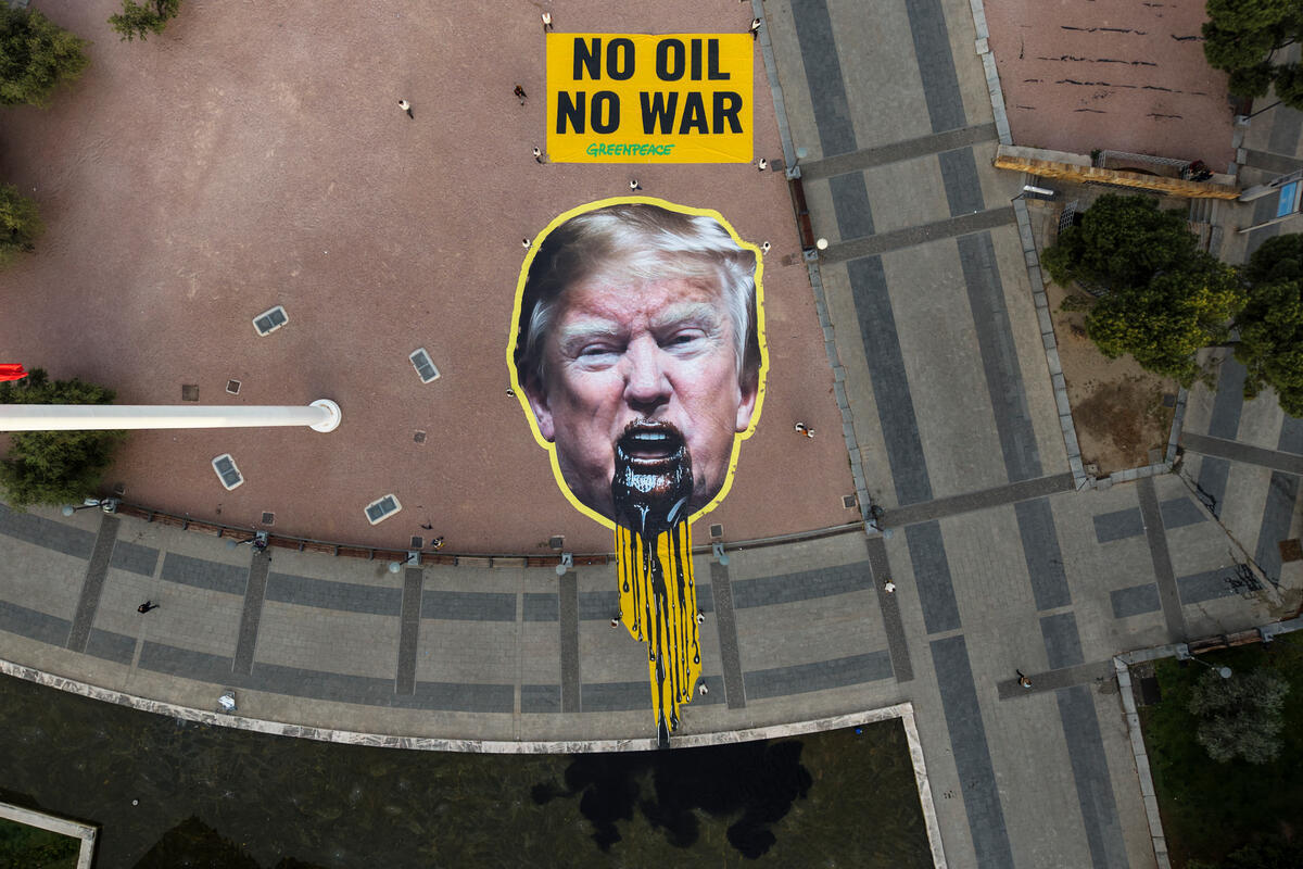 Greenpeace Spania demonstrerer i Madrid med et enormt bilde av Trump som kaster opp olje, og budskapet "ingen olje, ingen krig", i forkant av Santa Marta-konferansen om fossil utfasing.