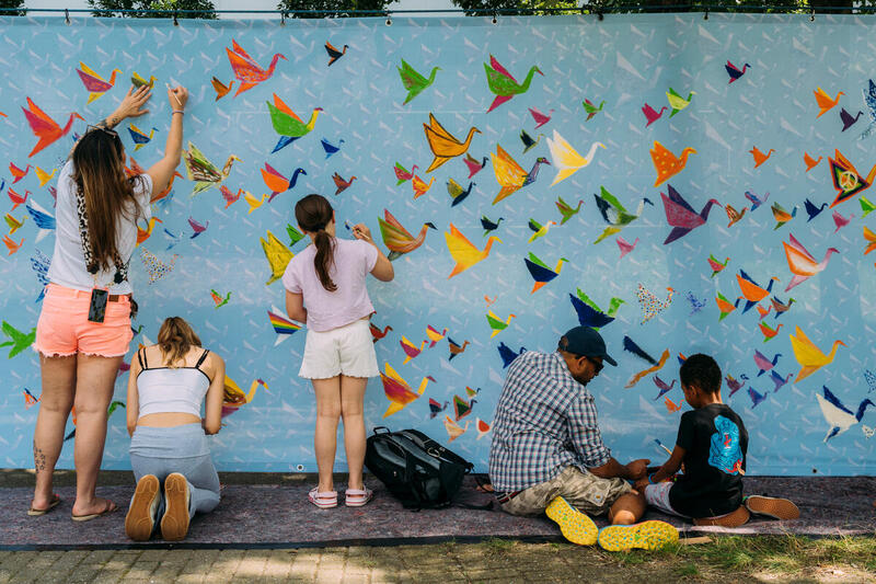 People painting thousand Cranes Mural-Banner on Hiroshima Peace Memorial Day in HamburgTausend Kraniche