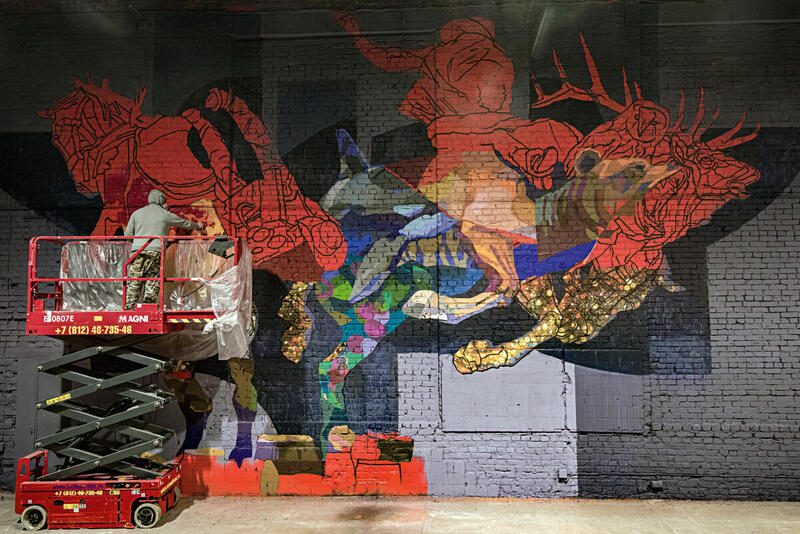 Alexey Mednoy creating a Mural while standing on a lift.