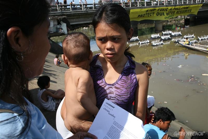 A Greenpeace volunteer talks to a local resident beside Marilao River in Bulacan, 25 kilometers north of Manila. Marilao River has been identified by the Department of Environment and Natural Resources (DENR) as one of the Philippines 50 dead rivers due to heavy pollution.