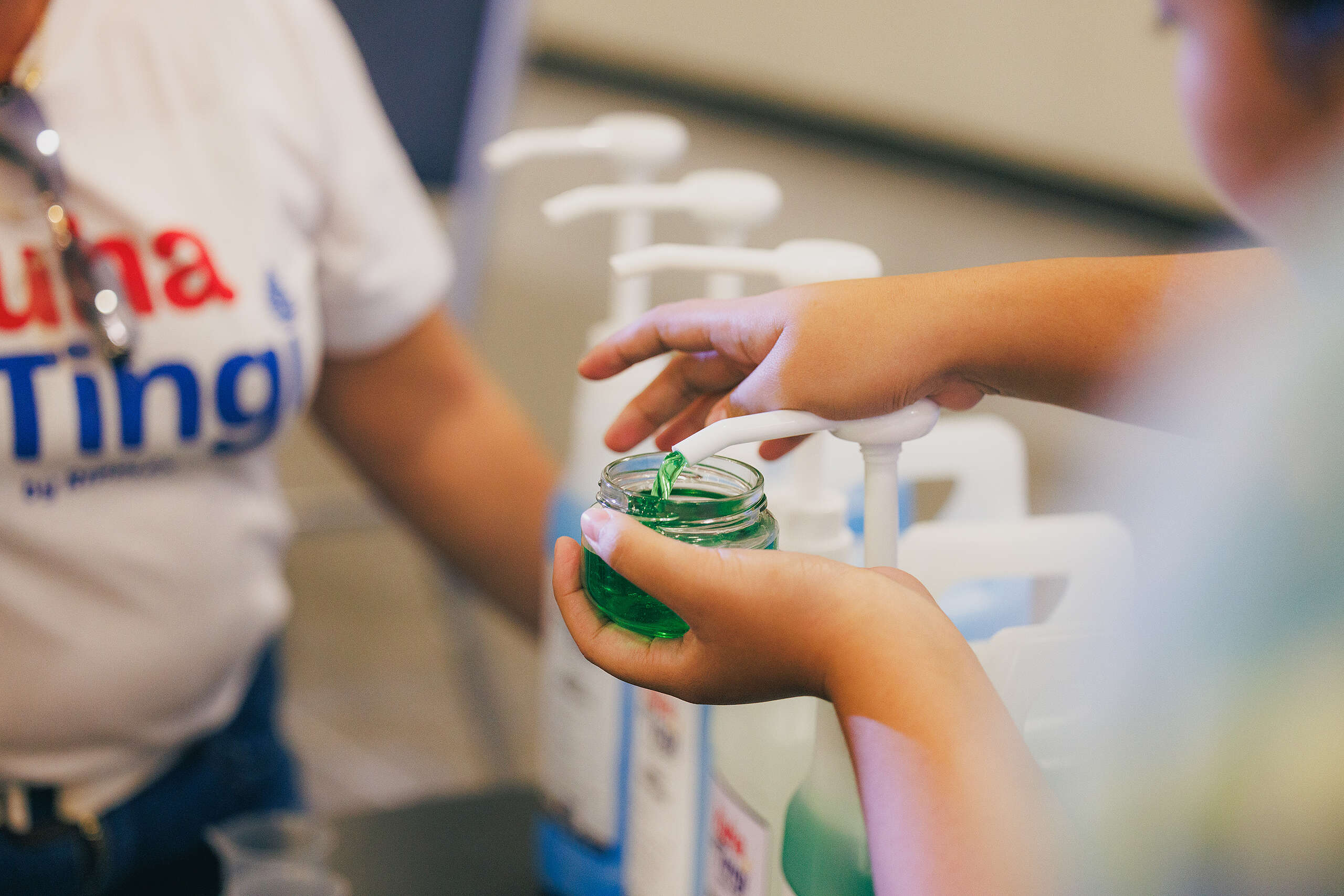 An attendee at the Kuha sa Tingi Report Launch refills a small jar through dispensers, as seen in sari-sari stores participating in the project. Photo by Jilson Tiu/Greenpeace