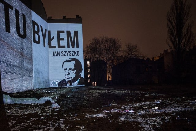 Projekcja napisu Tu byłem Jan Szyszko z portretem ministra na ścianie budynku, obok którego doszło do wycinki na mocy Lex Szyszko