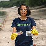 Marian Ledesma from Greenpeace Philippines picks up a piece of plastic trash from the company Dove around Freedom Island at Las Pinas, Philippines.