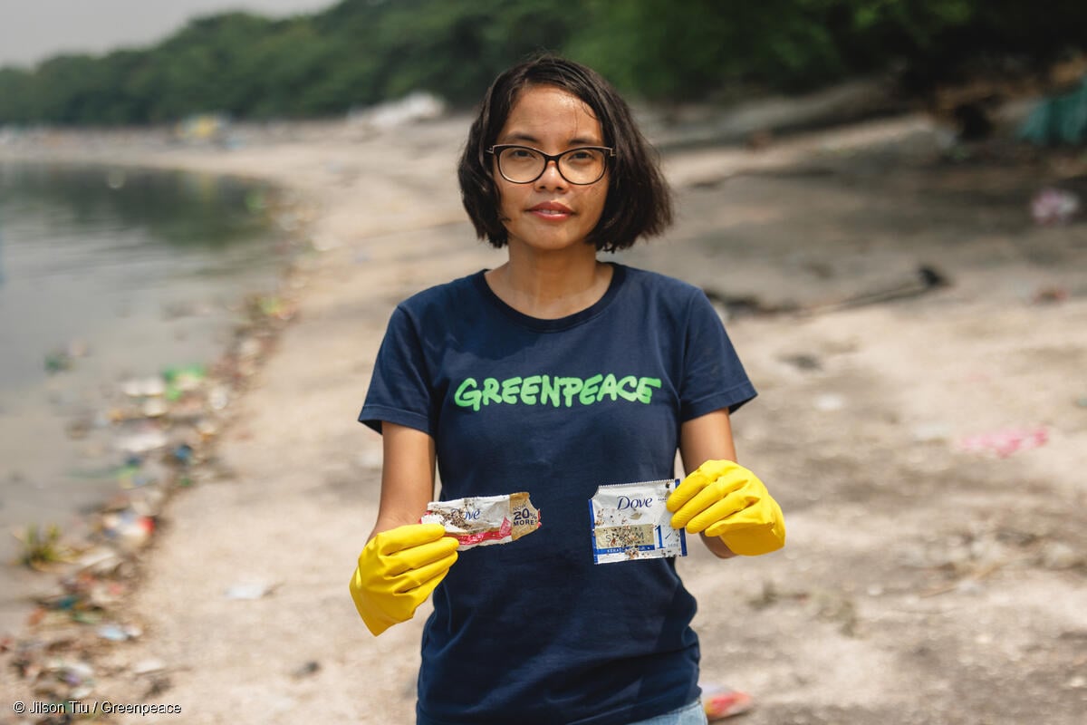 Marian Ledesma from Greenpeace Philippines picks up a piece of plastic trash from the company Dove around Freedom Island at Las Pinas, Philippines.