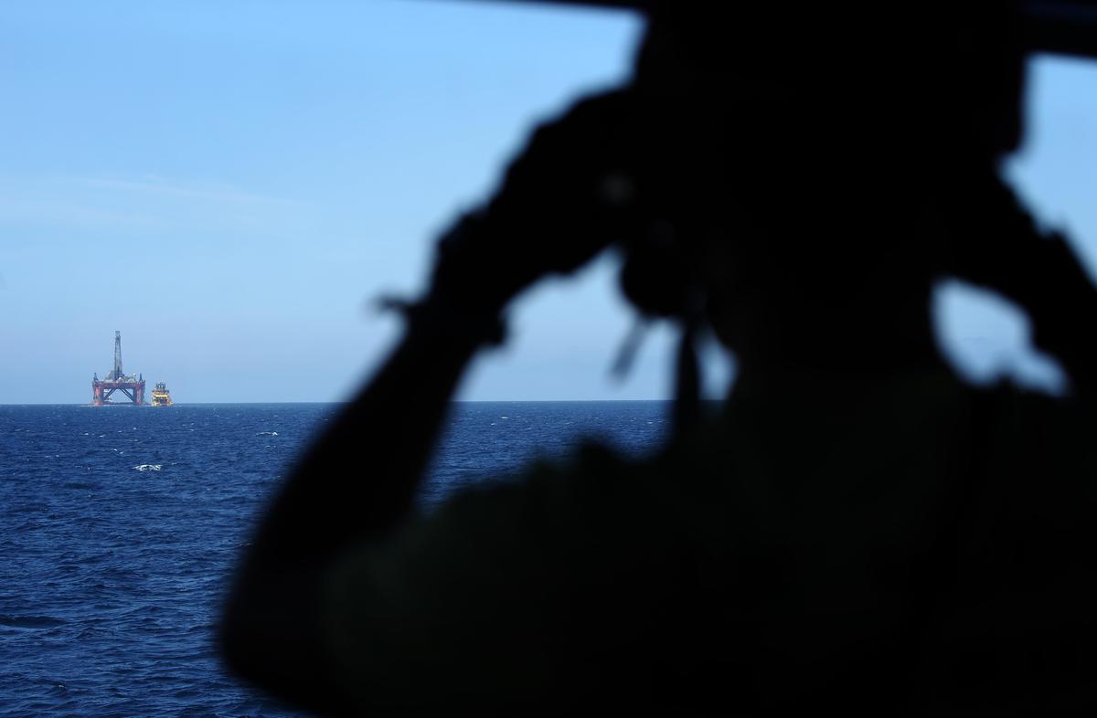 Crew member watches BP chartered oil rig in North Sea. © Greenpeace