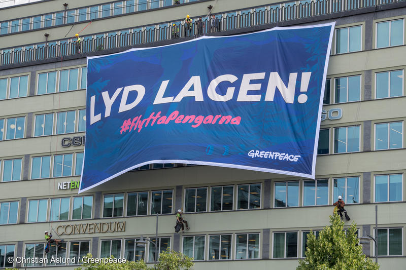 Aktivisterna från Greenpeace har hängt upp tavlor i Tredje AP-fondens mötesrum och en banner från myndighetens tak med texten ”Lyd Lagen, Flytta Pengarna