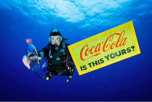 En dykare från Greenpeace med en colaflaska som hittats i havet. Foto: Justin Hofman/Greenpeace