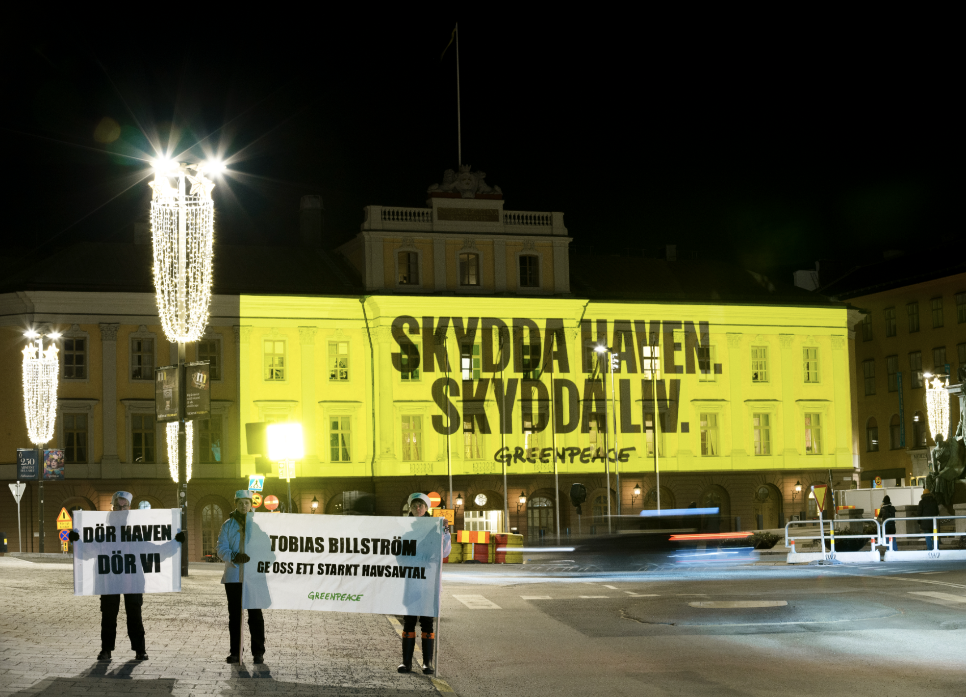 Aktivister i Sverige dframför projicering som säger Skydda haven, skydda liv.