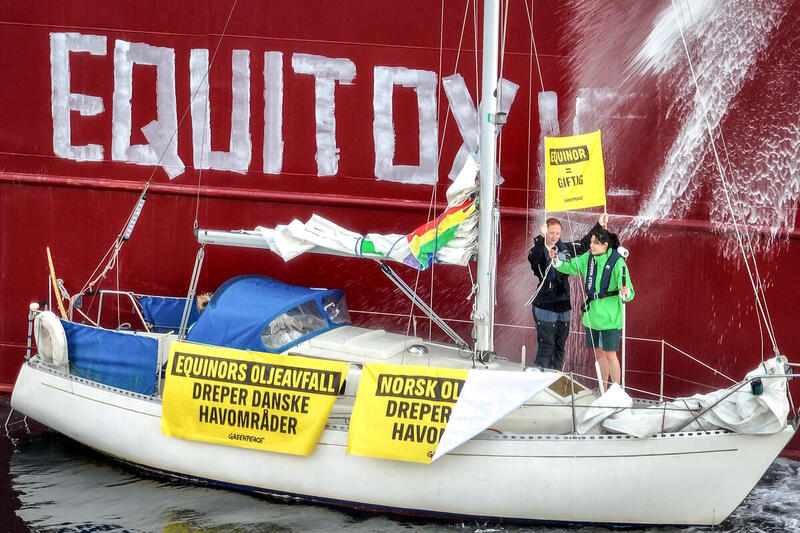 Aktivister i segelbåt har skrivit "Equitox" på sidan av tankfartyg i protest mot att det exporterar giftigt spillvatten till danska vatten.