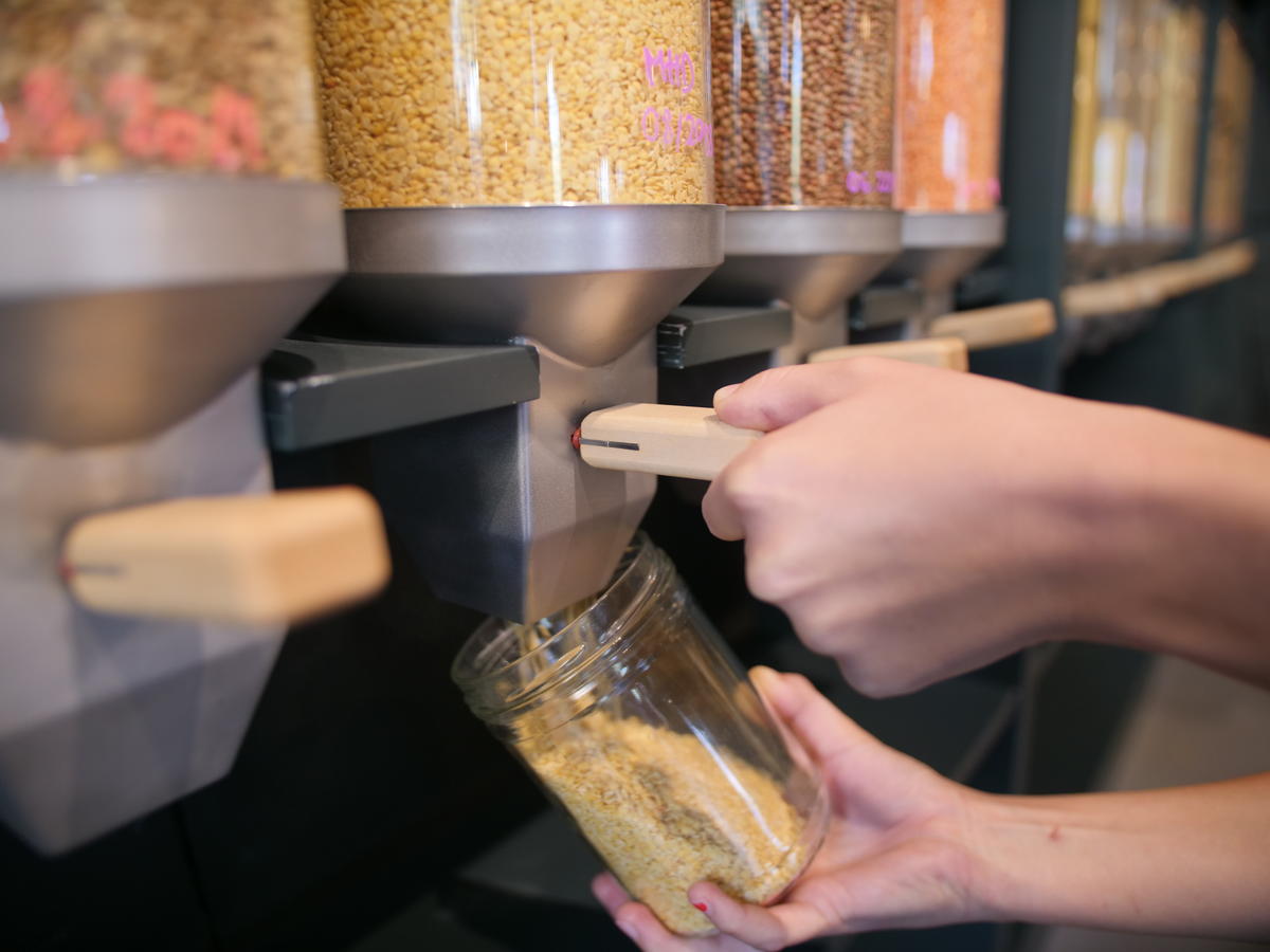 Zero Waste Shop Zurich, container with food, person filling container. © Greenpeace