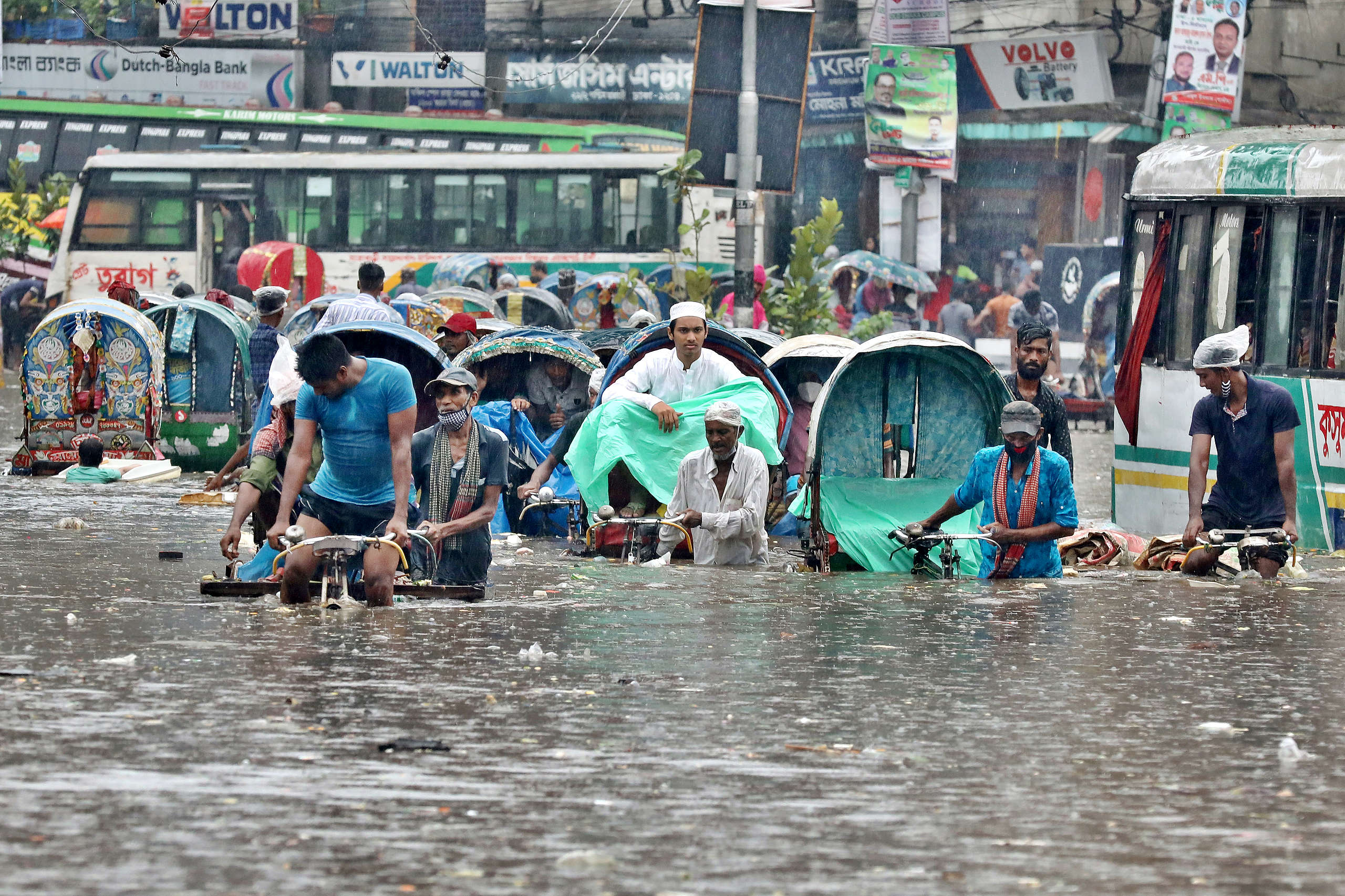 2020年7月21日,孟加拉首都達卡(Dhaka)因大雨造成淹水,行人與車輛在水深及腰的道路上前進。