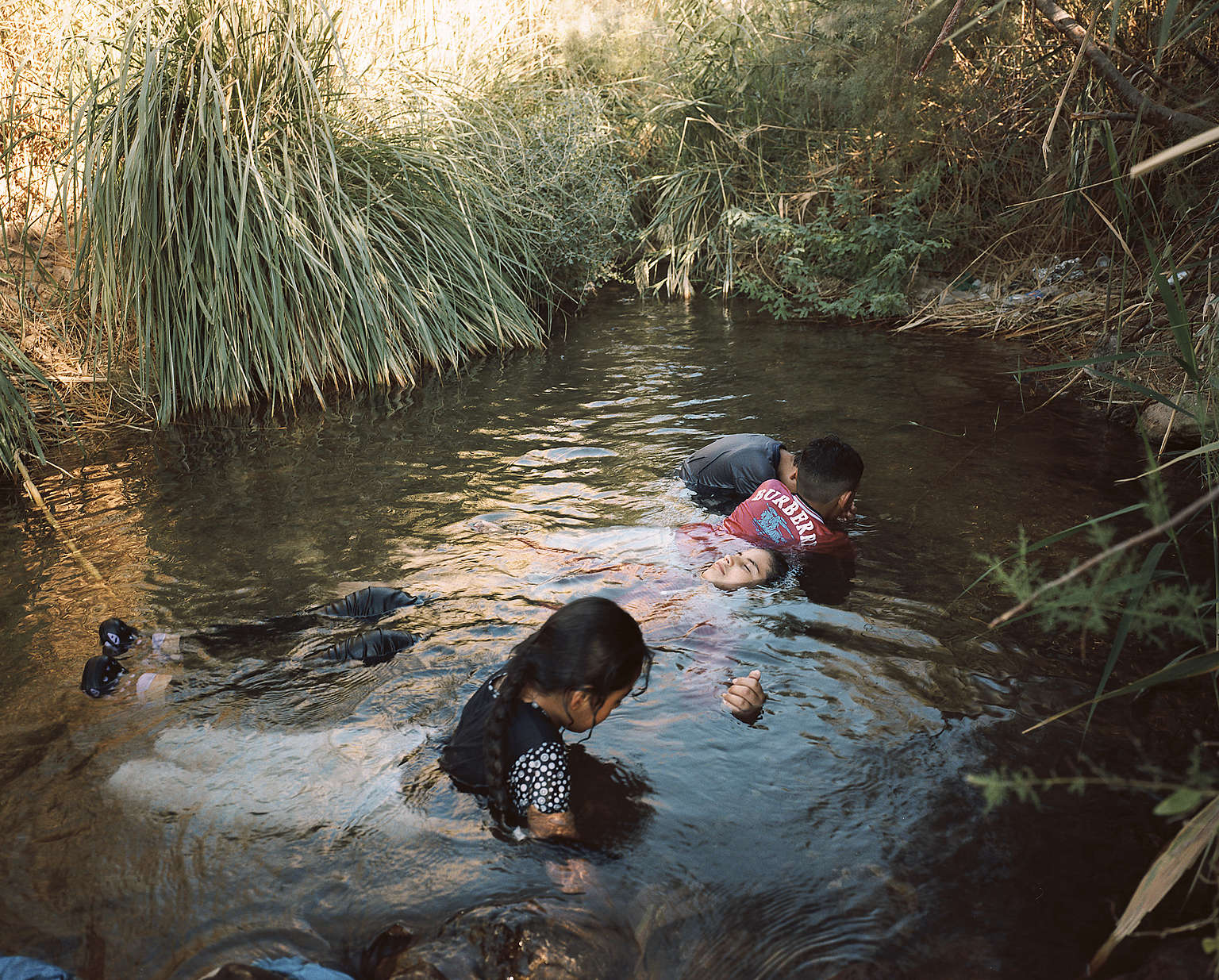 一群青少年正在尚未乾涸的約旦河谷中嬉戲，攝於2017年。