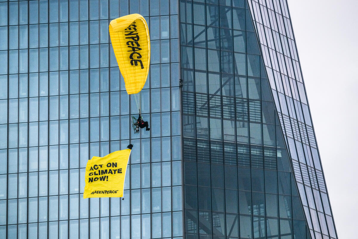 綠色和平行動者以滑翔傘（飛行傘）於歐洲中央銀行大樓前，以「立即為氣候行動」標語倡議，要求停止為化石燃料提供資金。