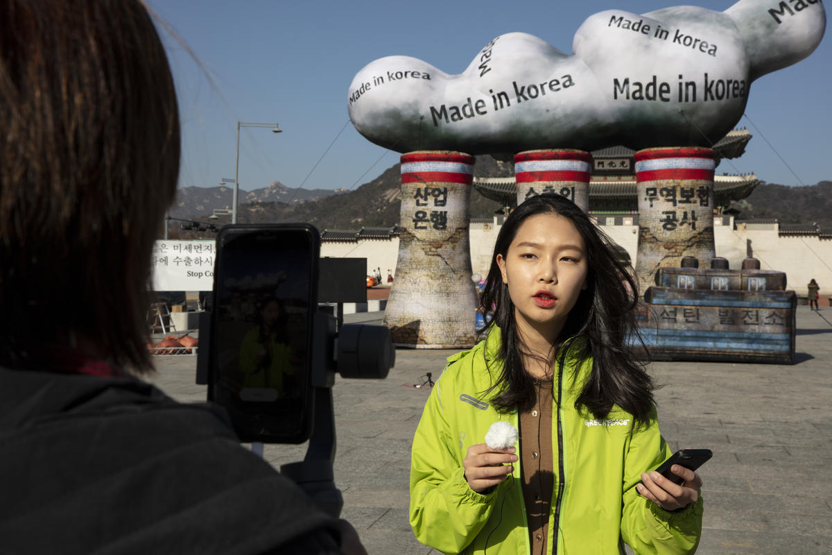 綠色和平行動者在韓國知名旅遊景點，位於青瓦台前的光化門廣場，設置了一座巨大的燃煤電廠，不僅向政府和公共金融機構倡議停止投資海外燃煤，也向民眾發送「空污棉花糖」，以提高公眾參與度與環保意識。© David Jaemin Byun / Greenpeace