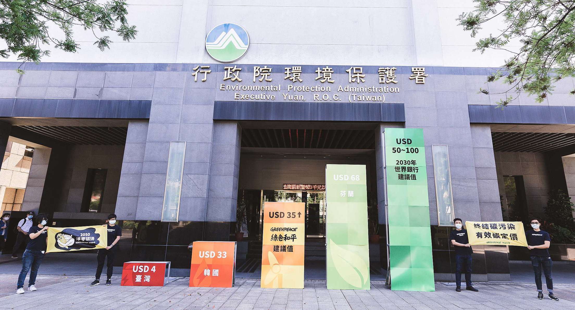 2021年世界地球日前夕,綠色和平在環保署門口豎立起巨大的碳定價裝置藝術,並向環保署代表遞交修法建議書,倡議制定有效碳定價。© Greenpeace