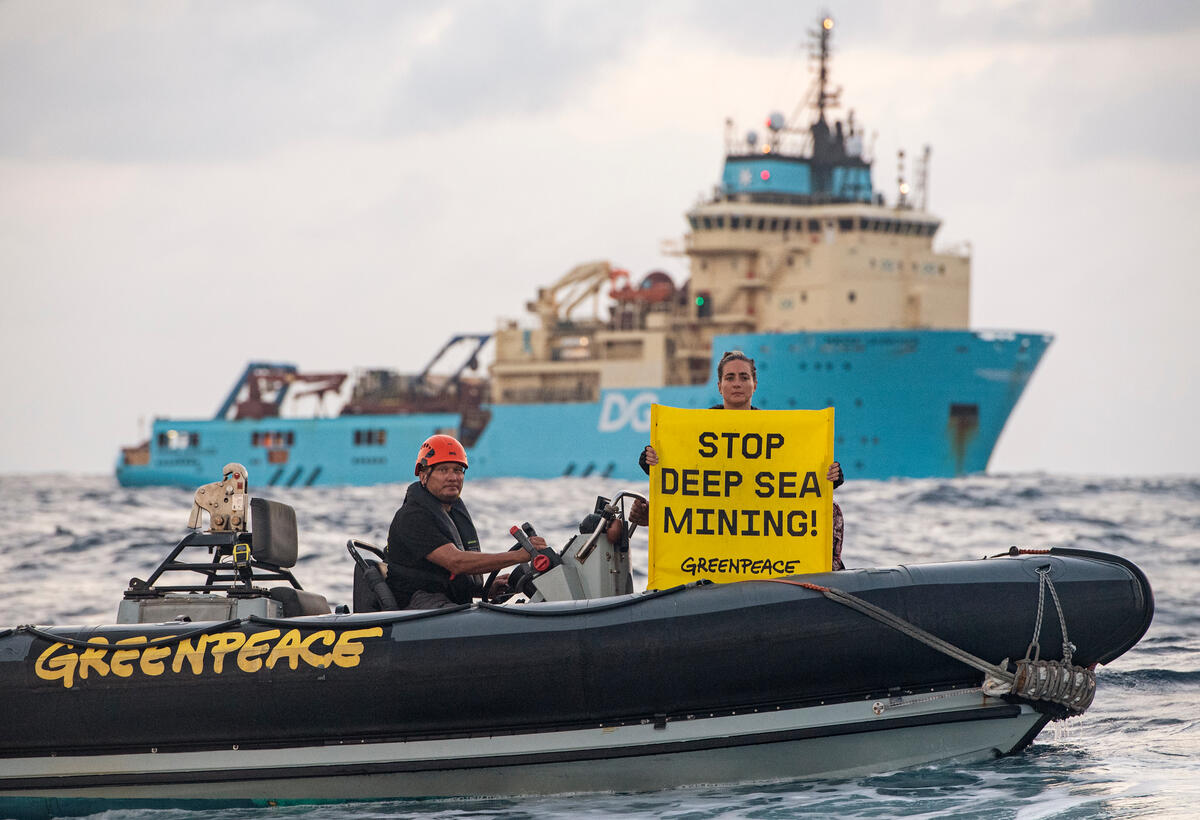 綠色和平行動者，在DeepGreen雇用的船艦前手舉「停止深海採礦！」布條，要求該企業停止破壞深海生態系統。