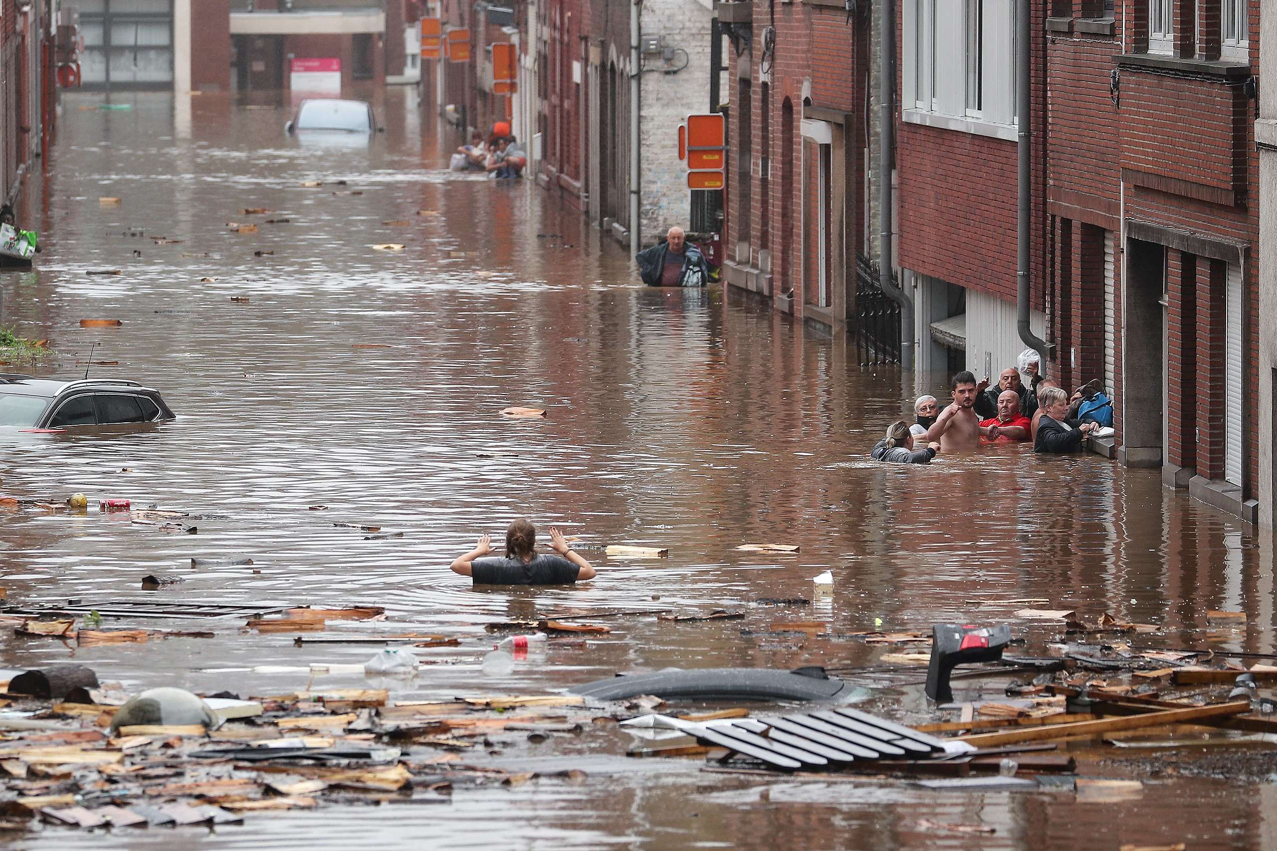 比利時淹水災況，列日大雨過後，一名婦女涉水穿過被淹沒的街道。